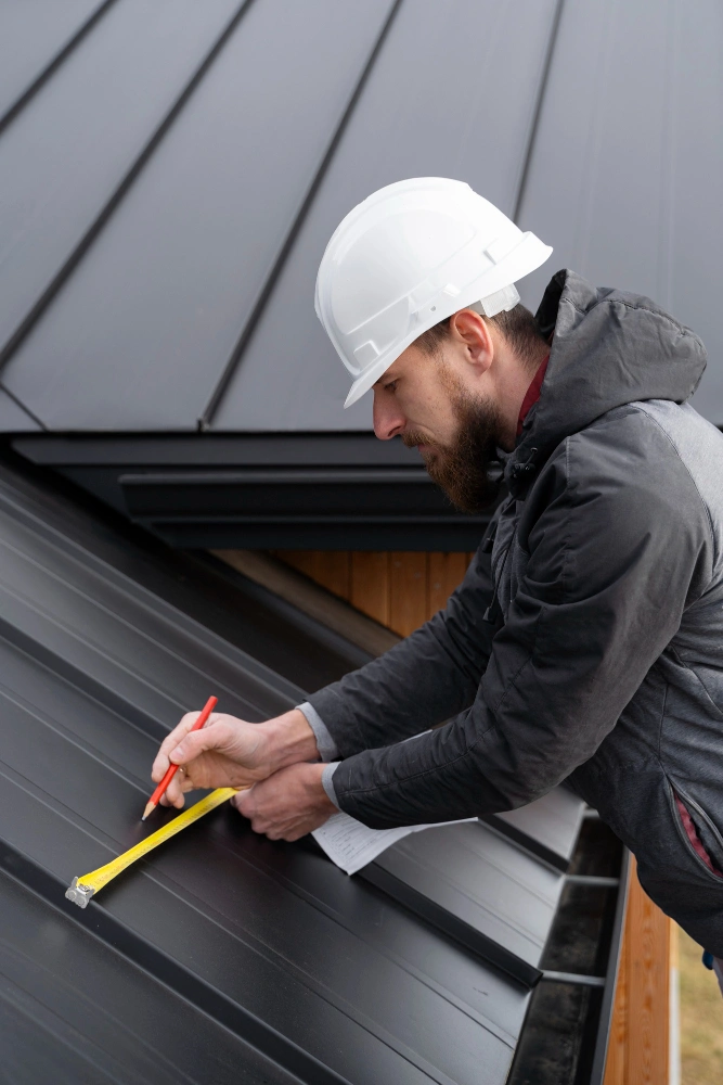 Roofing Pro LA technician measuring metal roofing panels during professional roof installation in Los Angeles